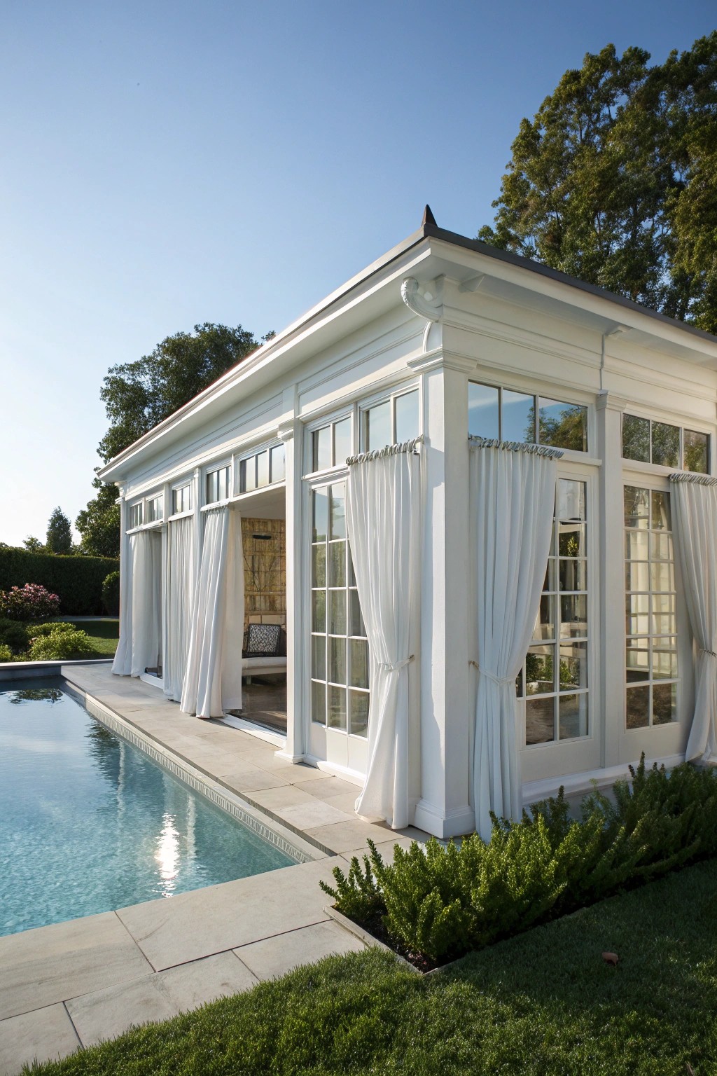 A timeless white pool house: where classic style meets serene simplicity.