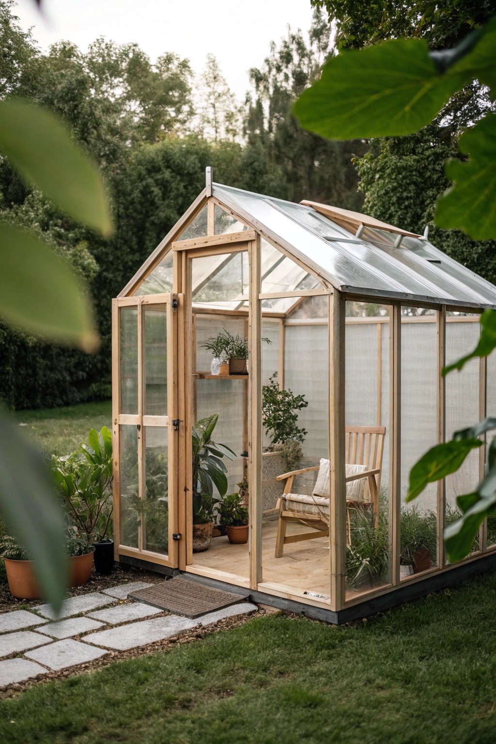 A serene glass-walled greenhouse nook—your personal escape in the backyard.
